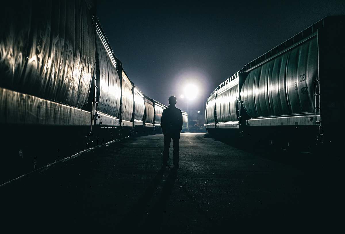 canada silhouette of man standing beside train dark