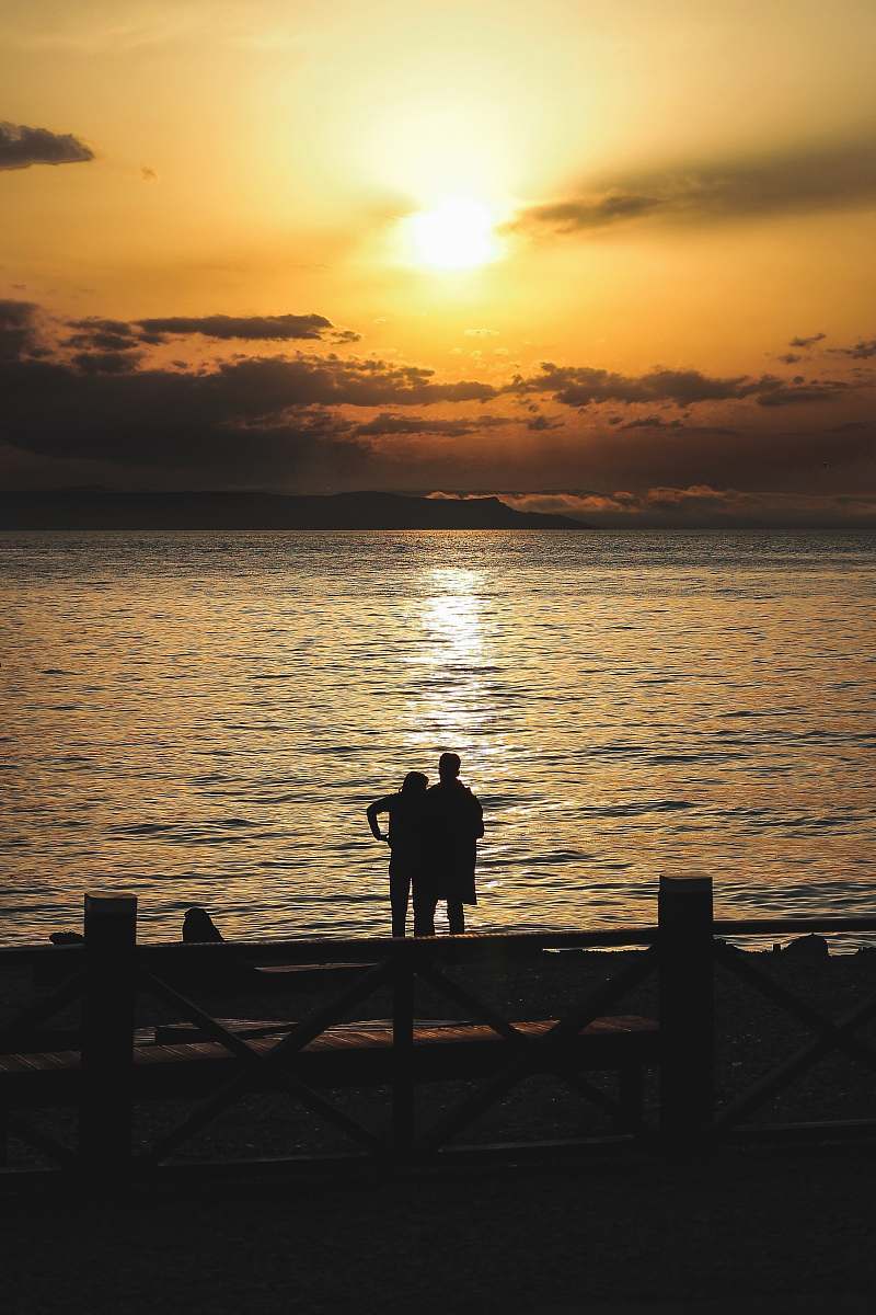 human silhouette of couple standing near sea person