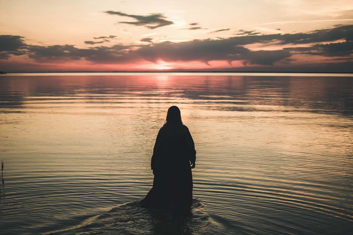 outdoors woman walking in sea during golden hour nature