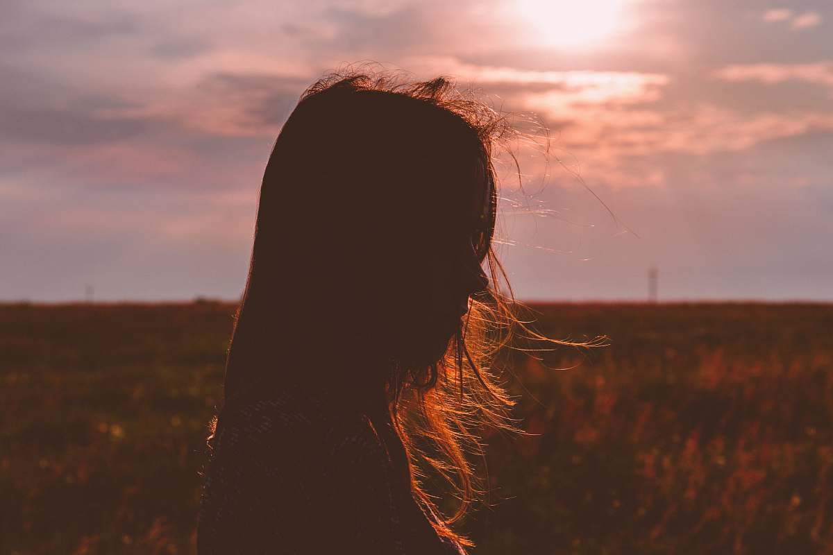 field silhouette photo of a woman grass