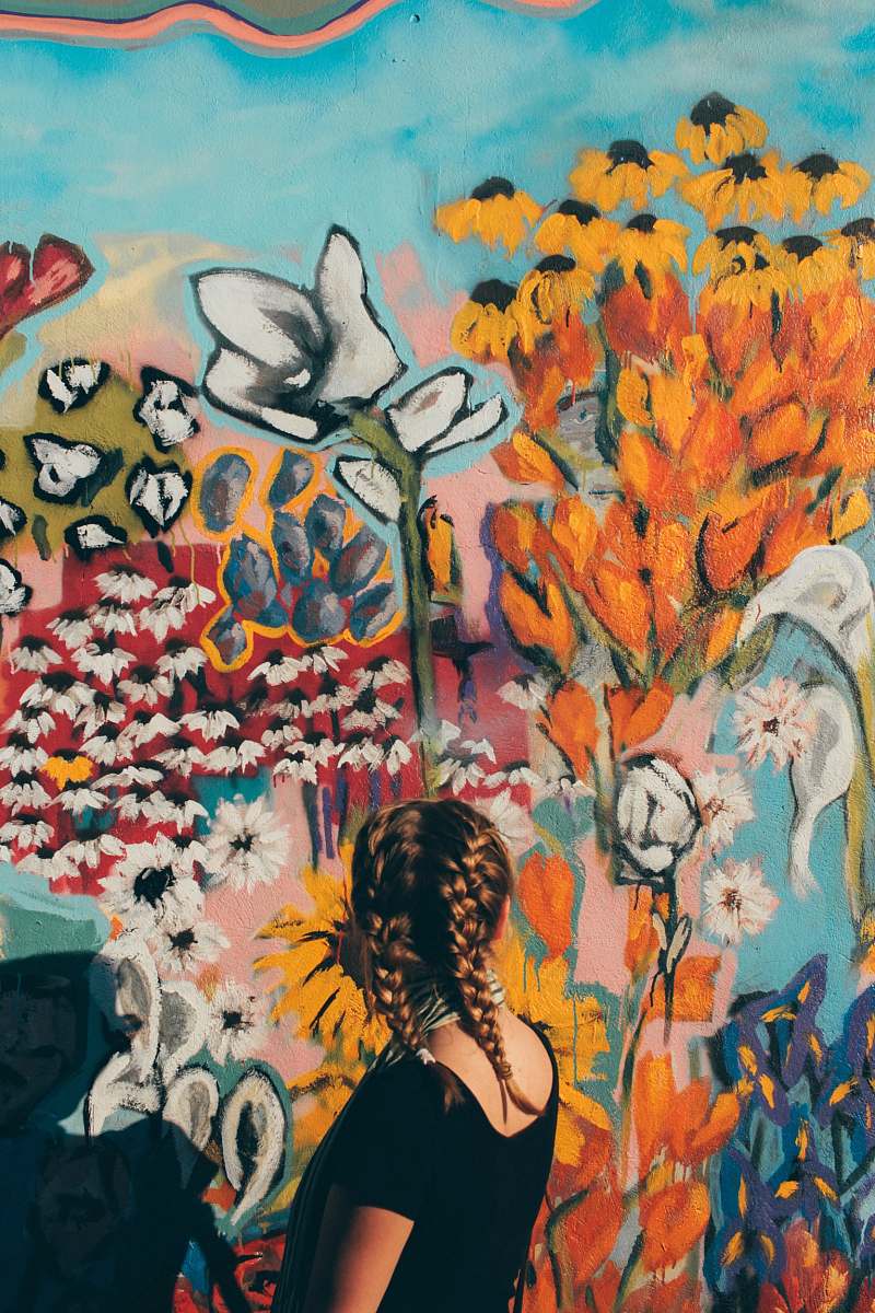 people woman facing in front of floral graffiti wall nashville