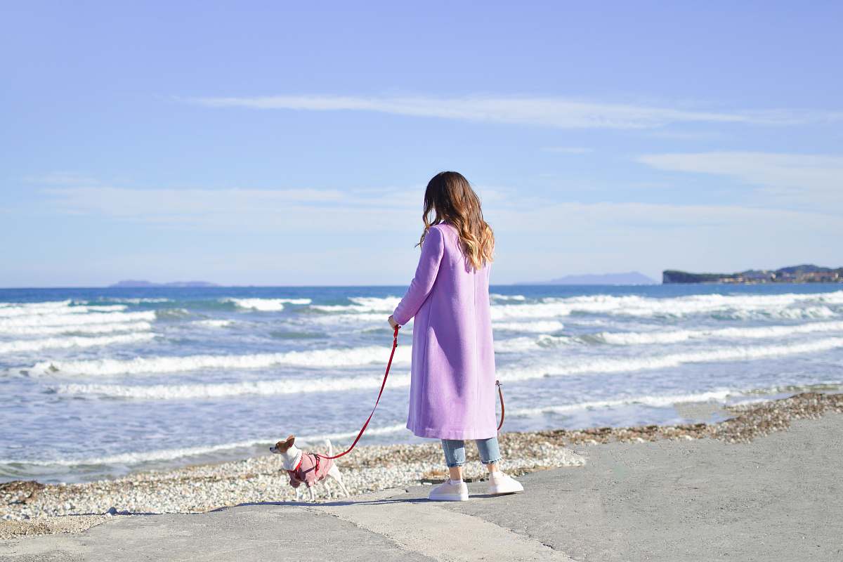 ocean person in purple trench coat near body of water sea