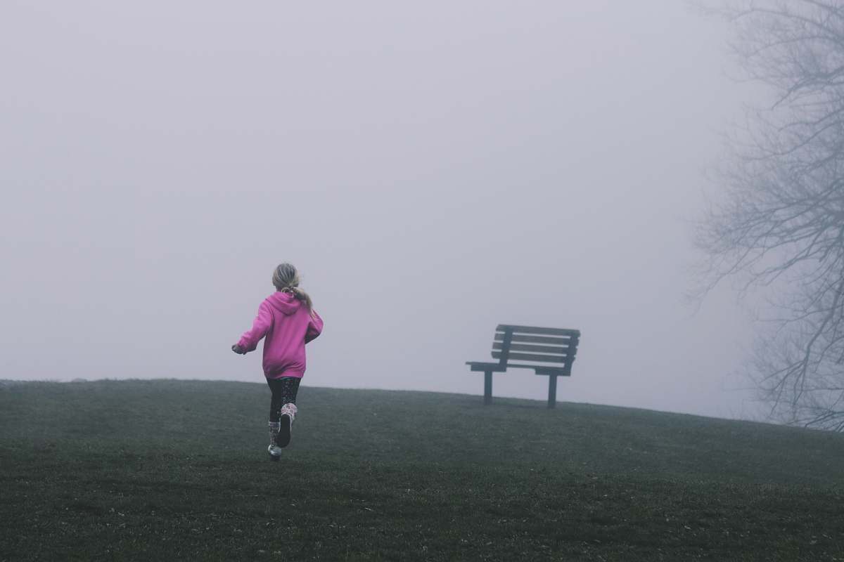 child girl running near black bench running