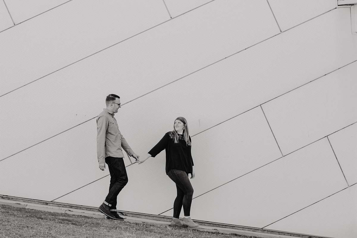 human grayscale photo of woman holding hand of man people