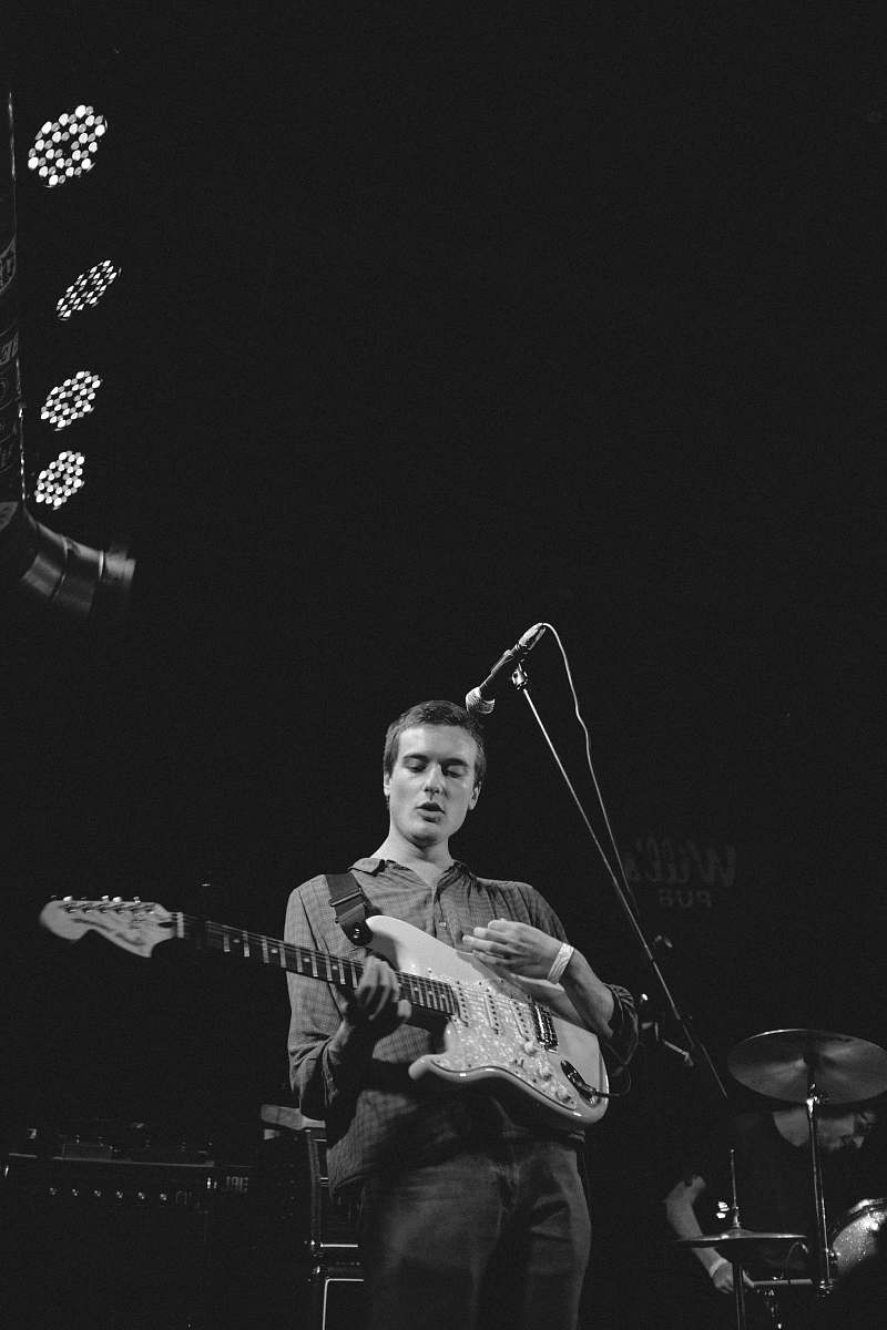 guitar grayscale photography of man playing guitar on stage musician
