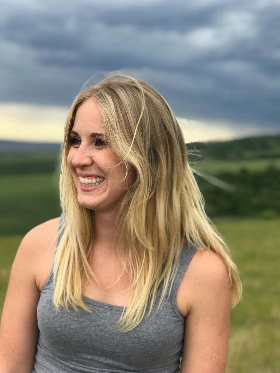 woman woman standing on open field while smiling selective focus photography girl