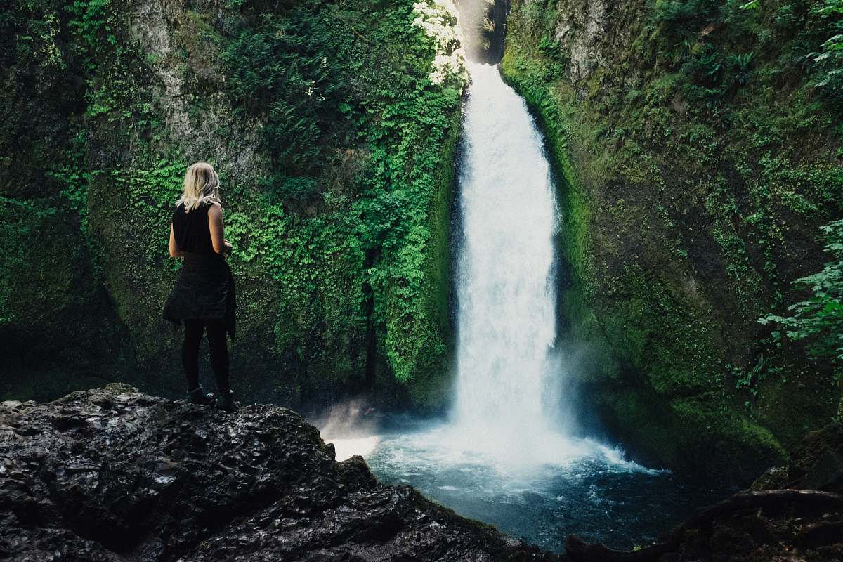 blonde woman in front of waterfalls woman