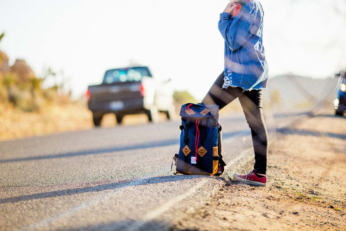 people black and blue backpack on road person