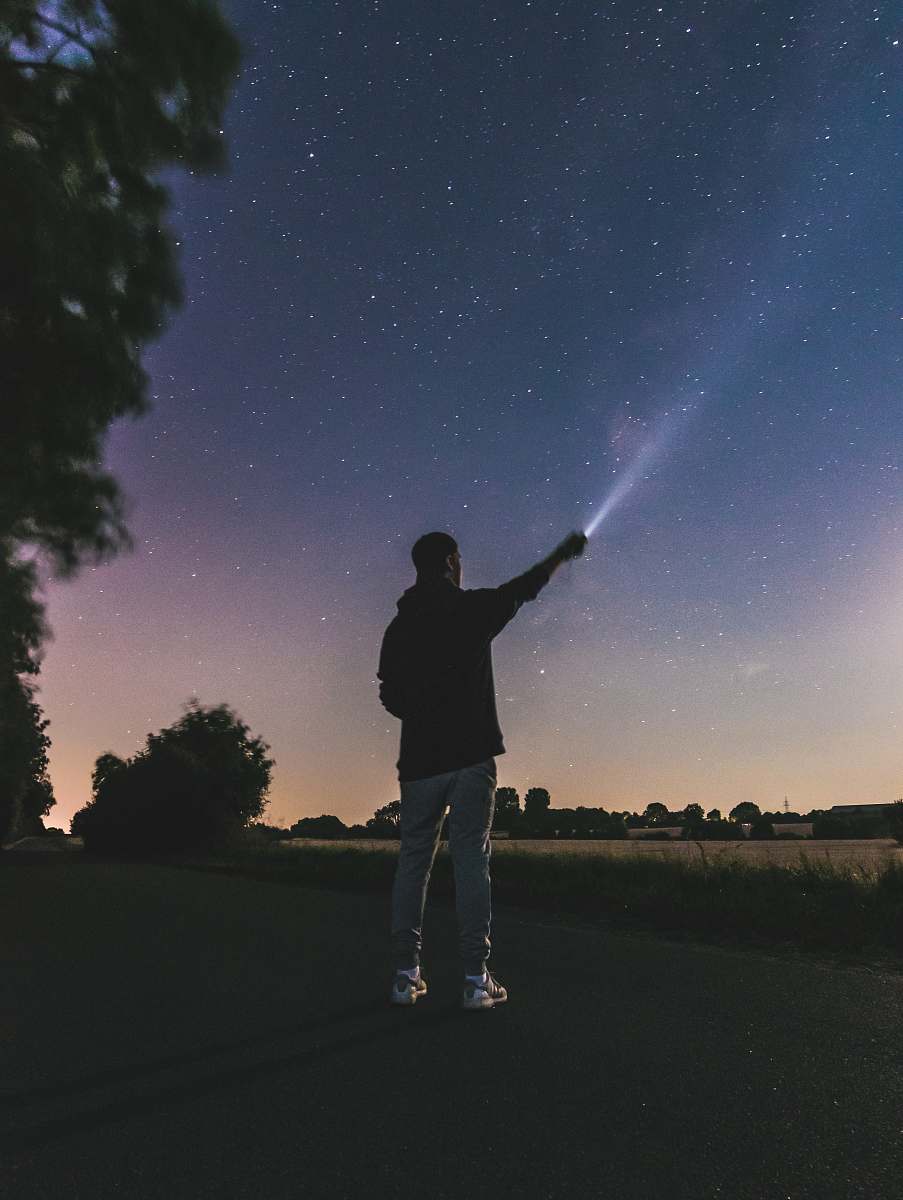 people force photography standing man using flashlight at star person