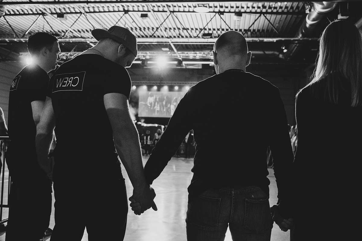 people four unknown person standing while holding hands black-and-white