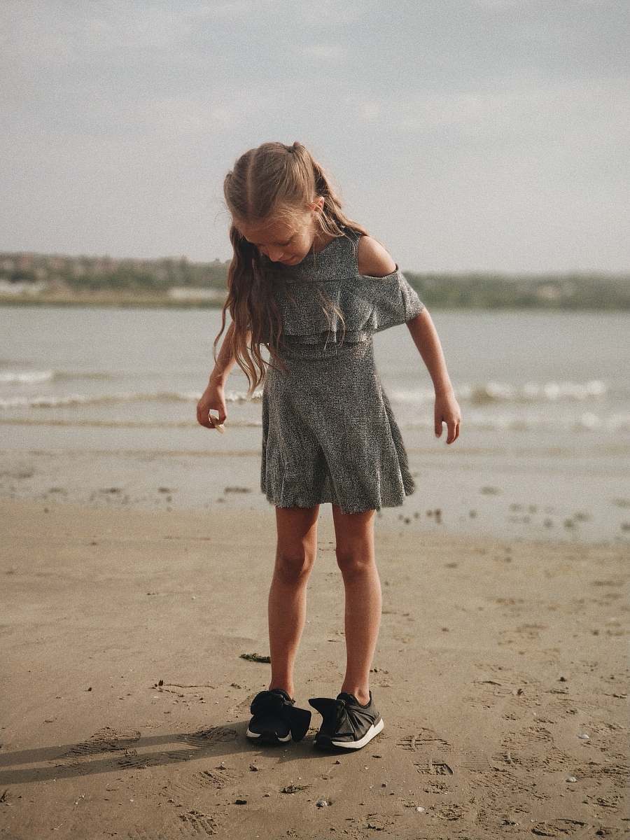 people girl wearing gray dress standing on shore person