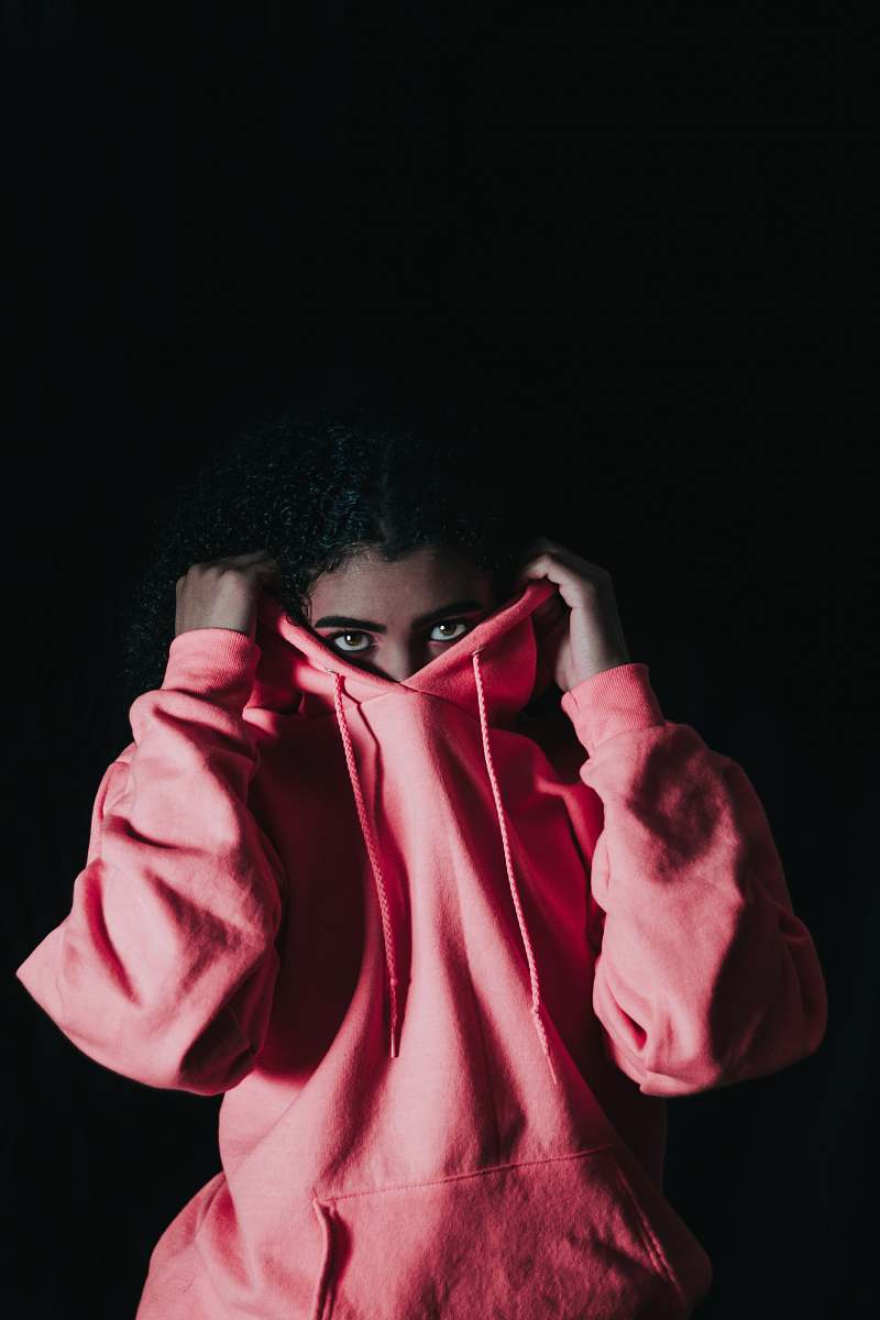 people girl wearing pink pullover hoodie covering her nose person