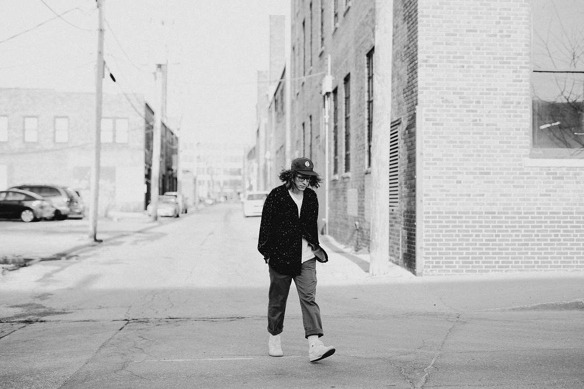 person grayscale photo of man walking on street black-and-white