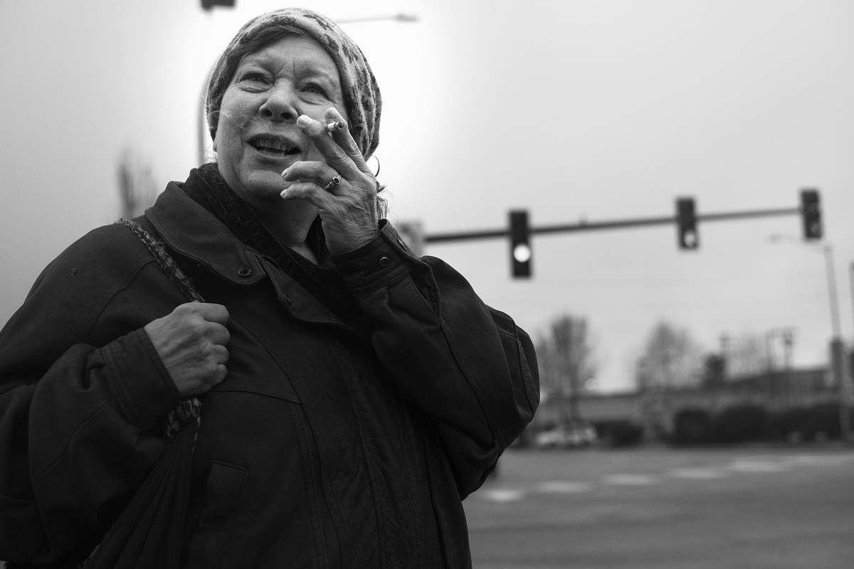 person grayscale photo of woman holding cigarette stick black-and-white
