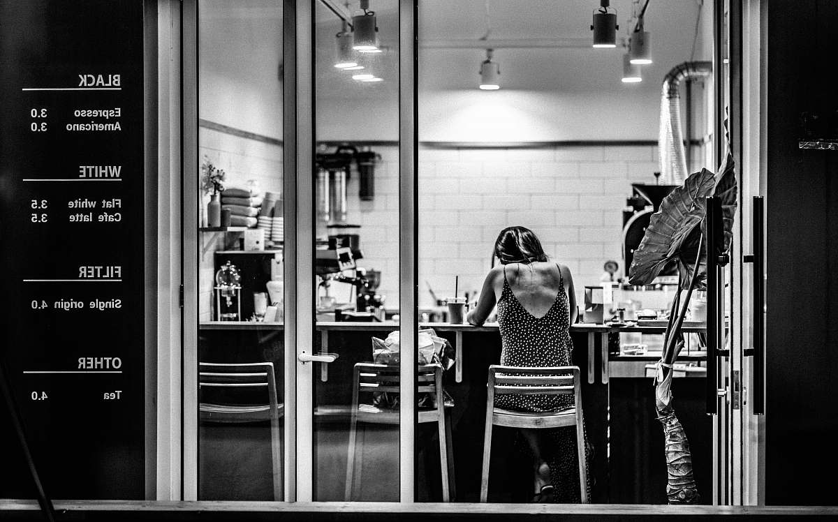 people grayscale photography of woman inside cafe black-and-white