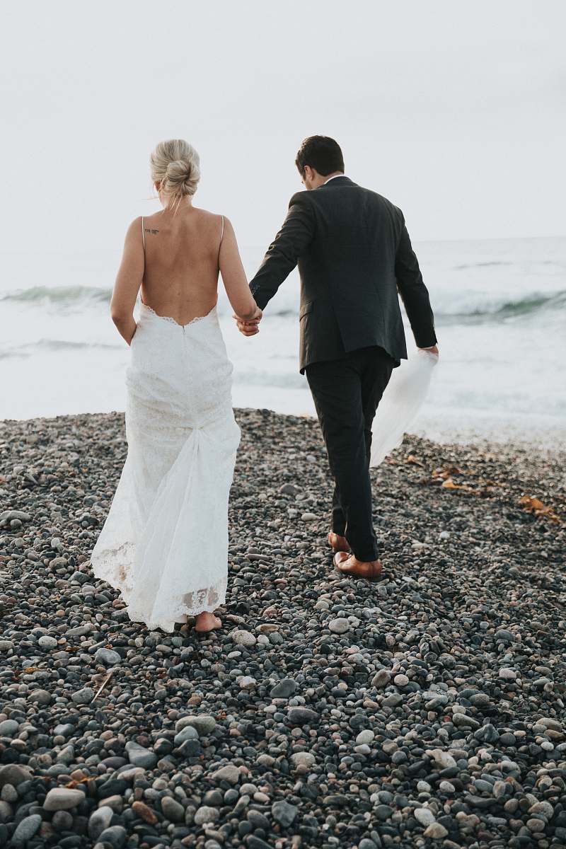 people groom and bride walking on stone near body of water person