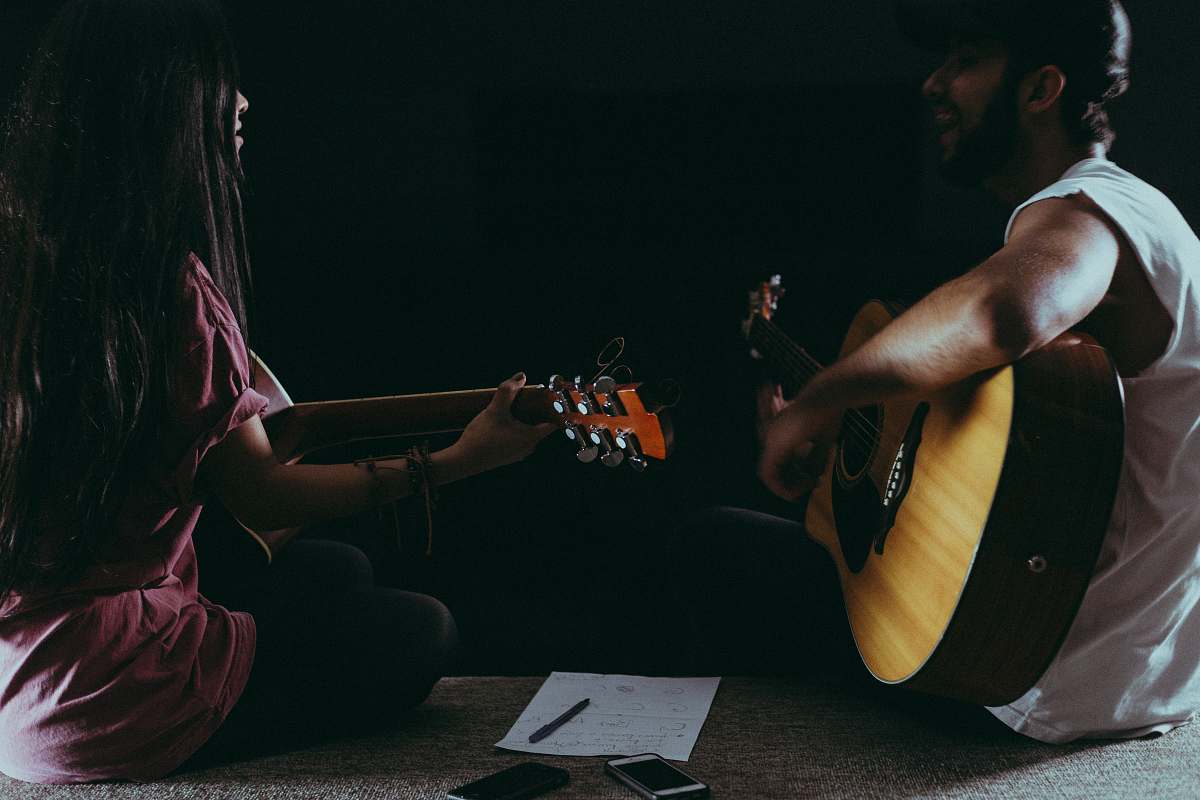 people man and woman playing guitars person