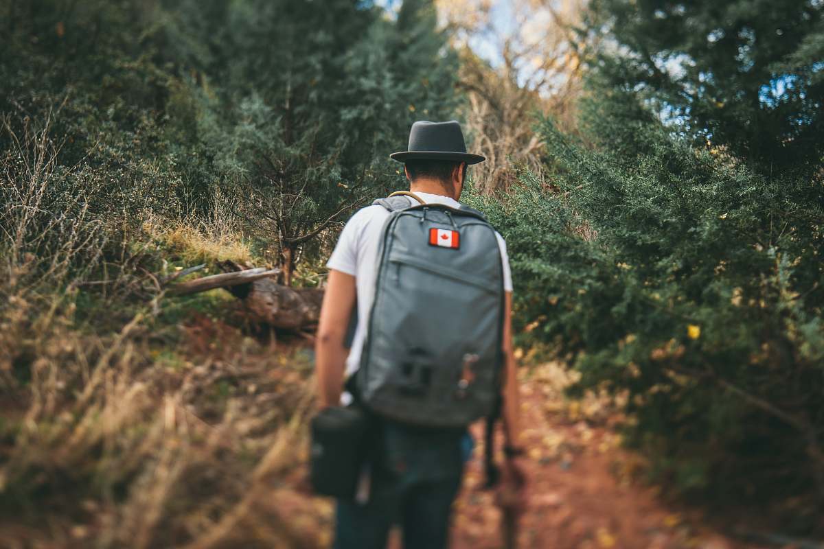 people man carrying gray backpack person
