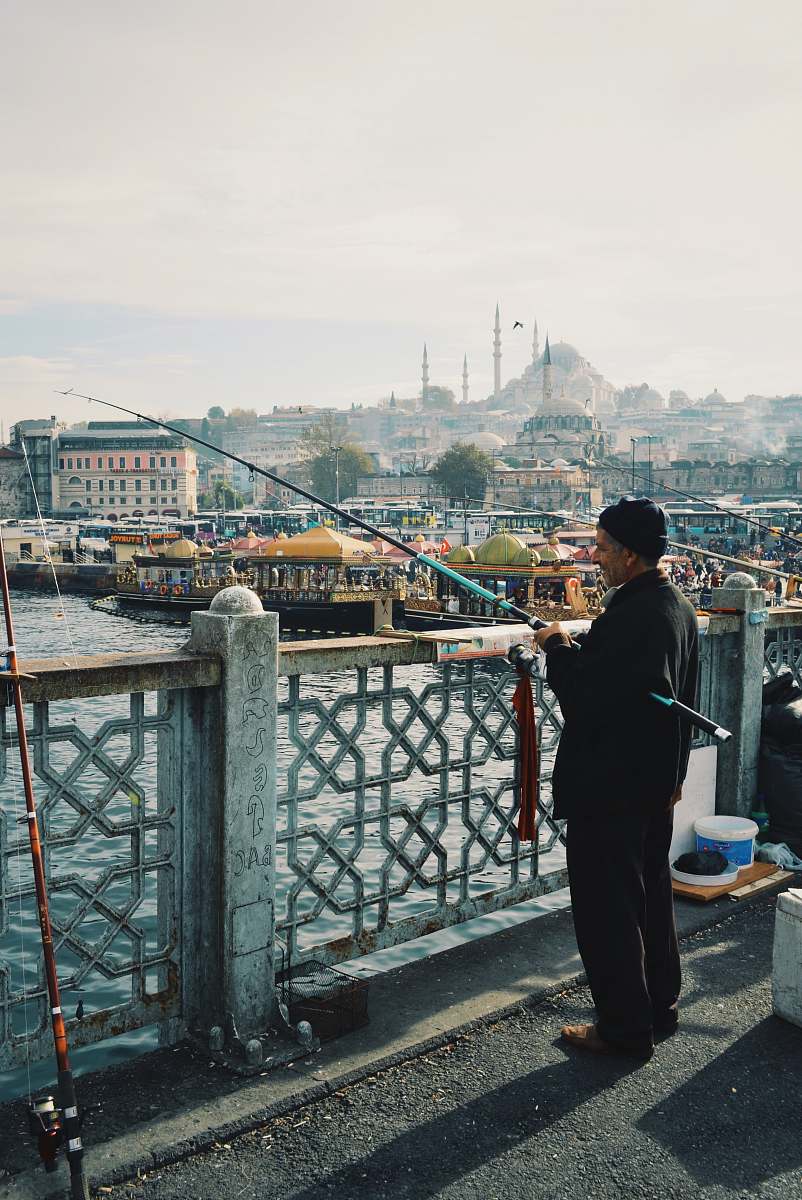 person man fishing using black and blue fishing rod people