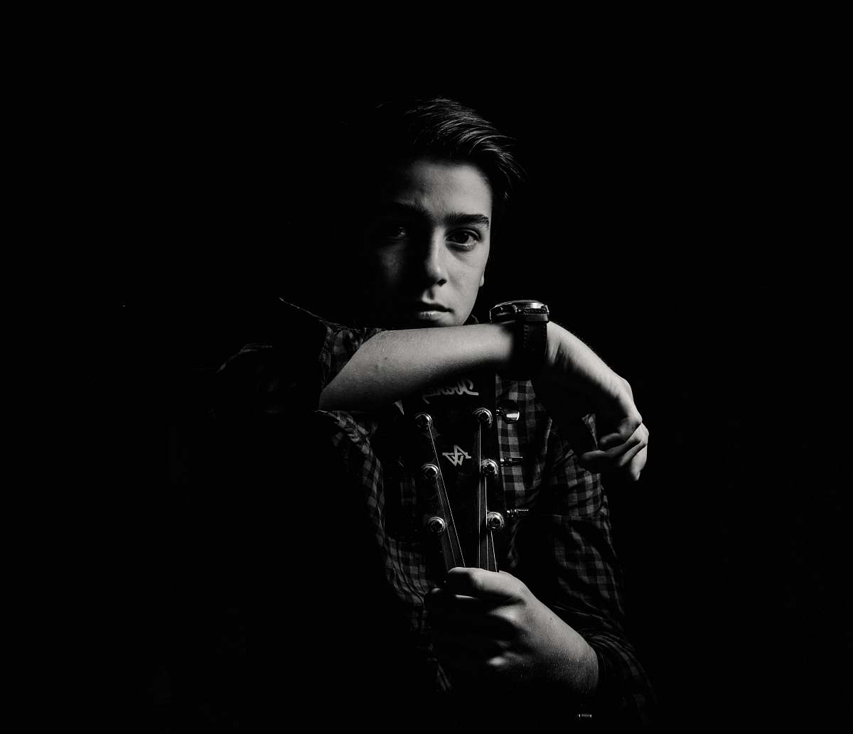 person man holding guitar black-and-white