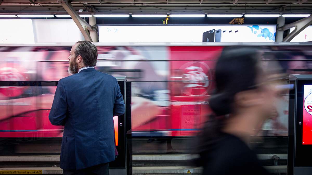 people man in black suit jacket standing train