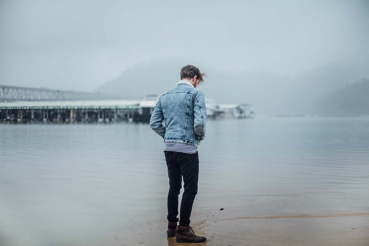 people man in blue denim jacket standing on shore person