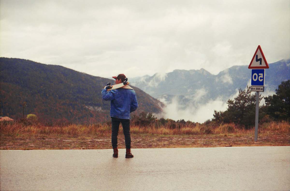 people man in blue jacket carrying skateboard person