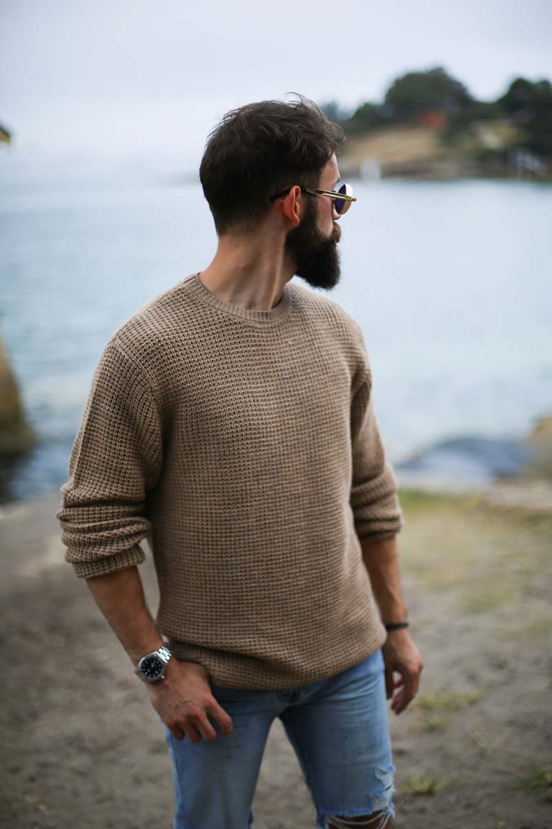 people man in brown knitted sweater near beach person