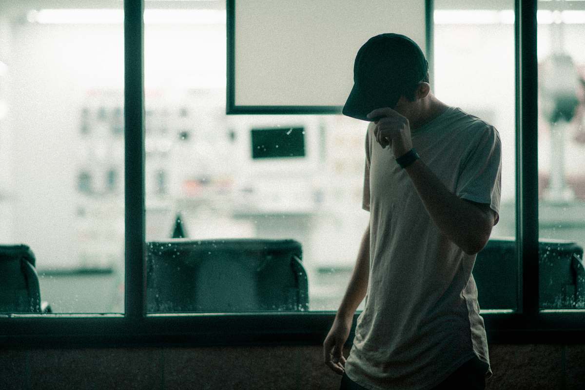 people man in gray crew-neck t-shirt holding his cap person