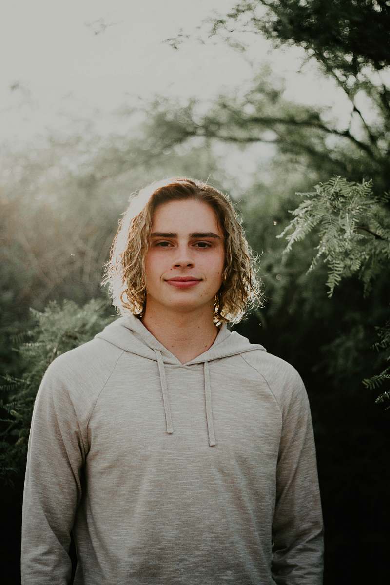 people man in gray hoodie near trees at daytime person