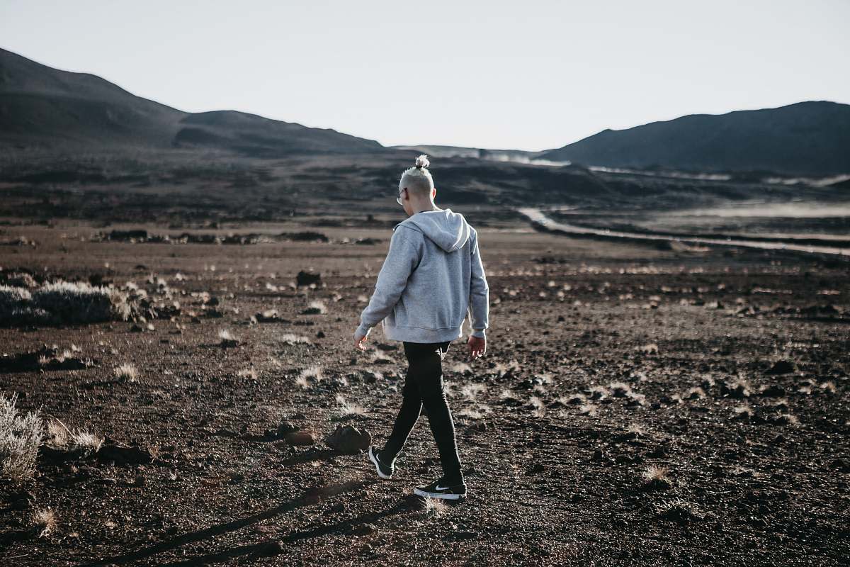 people man in hoodie walking on open field person