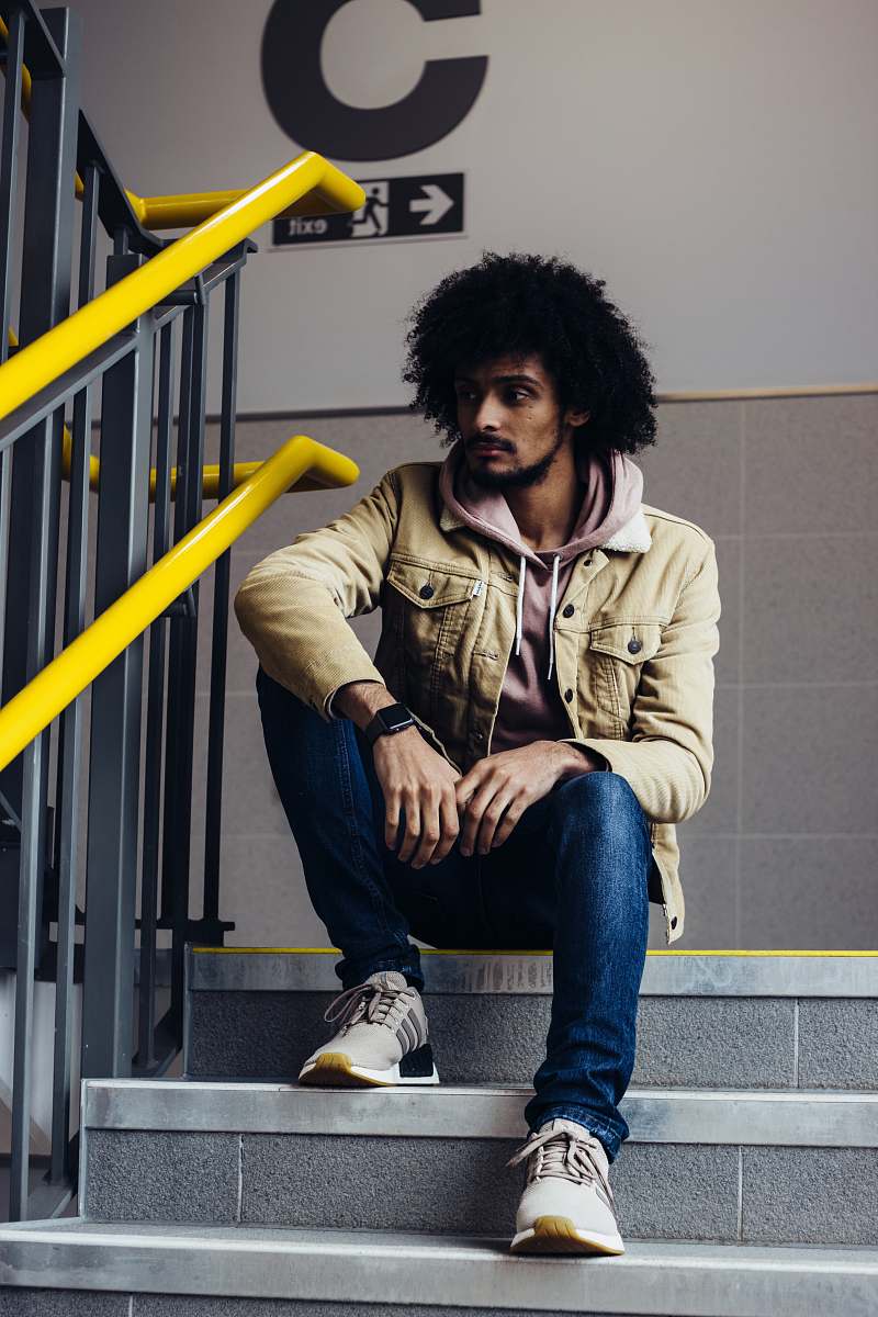 people man in zip-up jacket sitting on staircase person