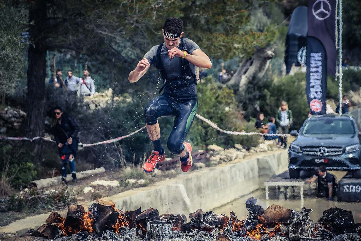 person man jumping on flaming charcoal people