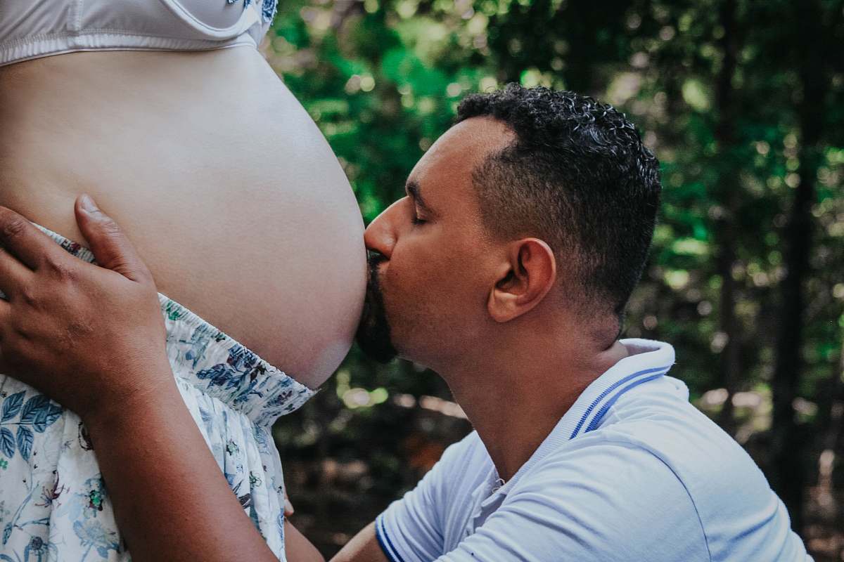 people man kissing on woman's pregnant womb person