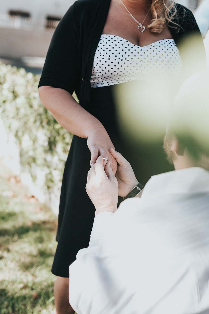 person man proposing to woman during daytime people