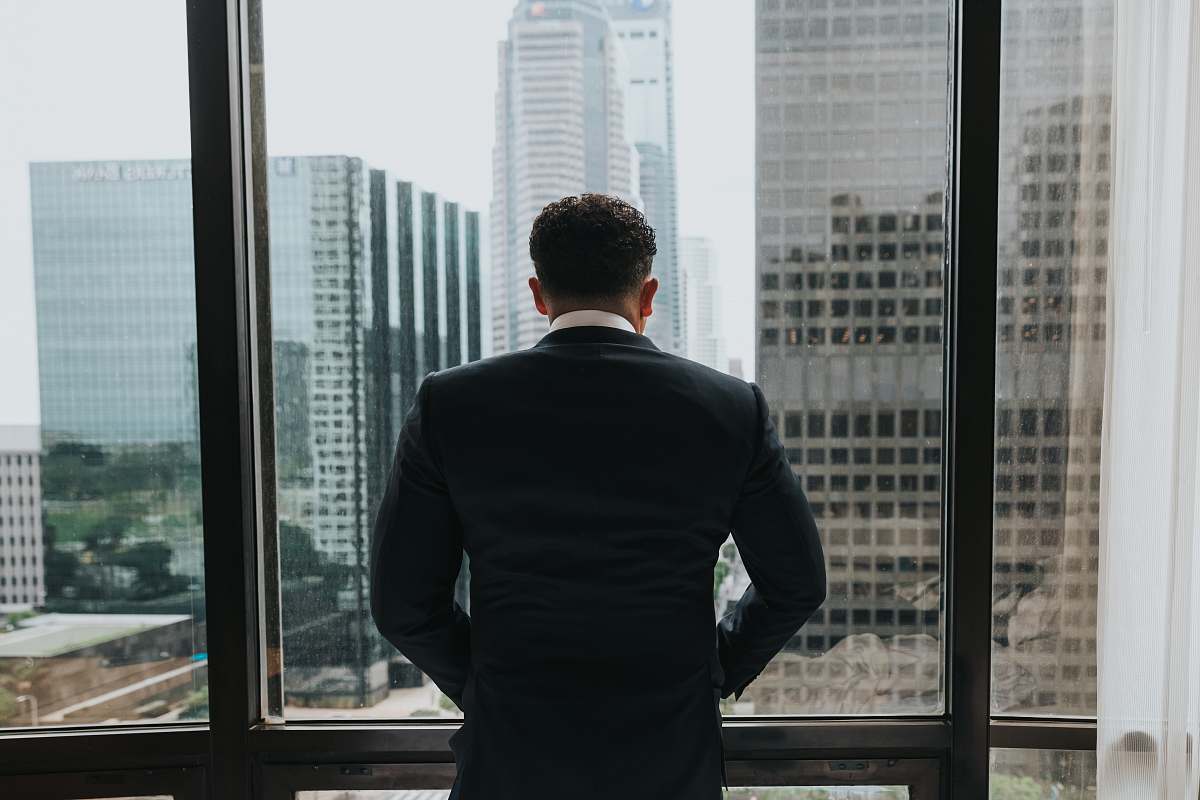 people man putting hands on pocket while standing in front of glass wall person