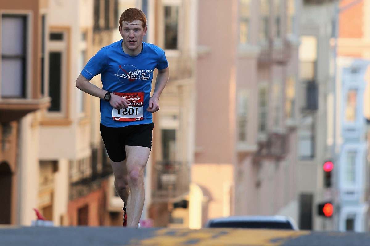 people man running on street surrounded with building person