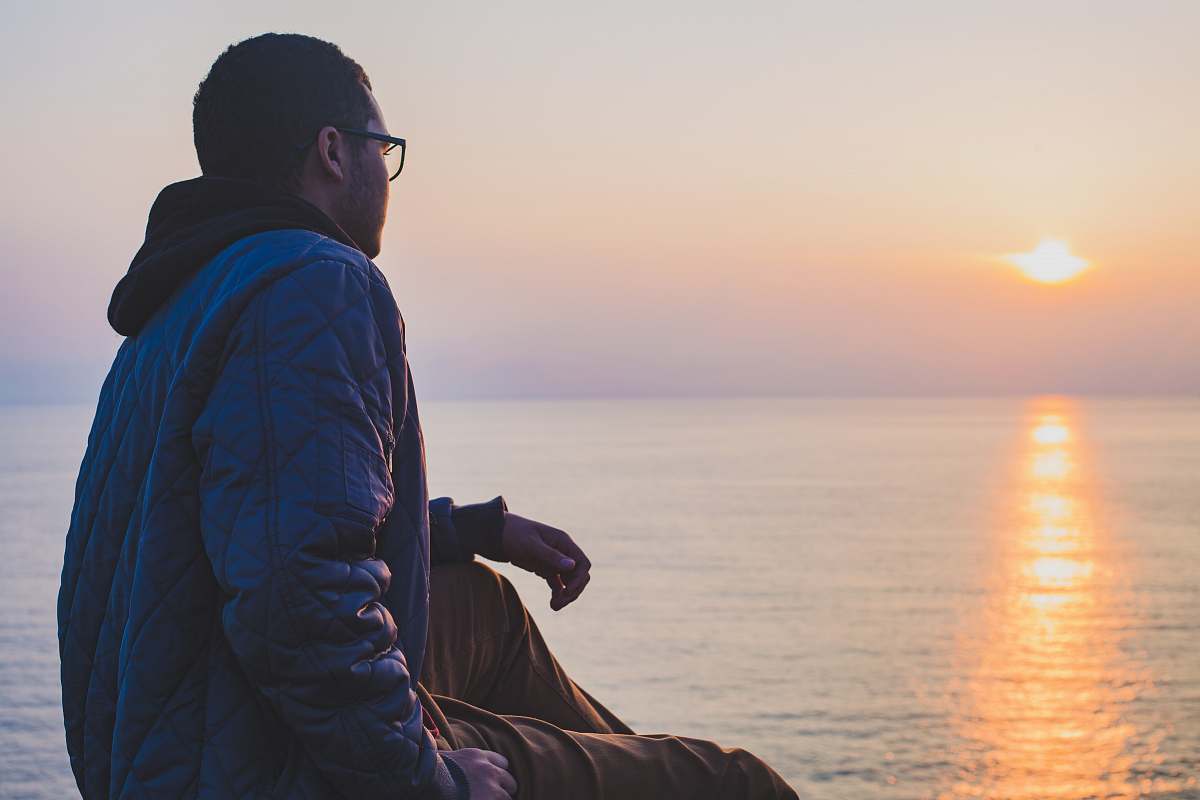 people man sitting near body of water person