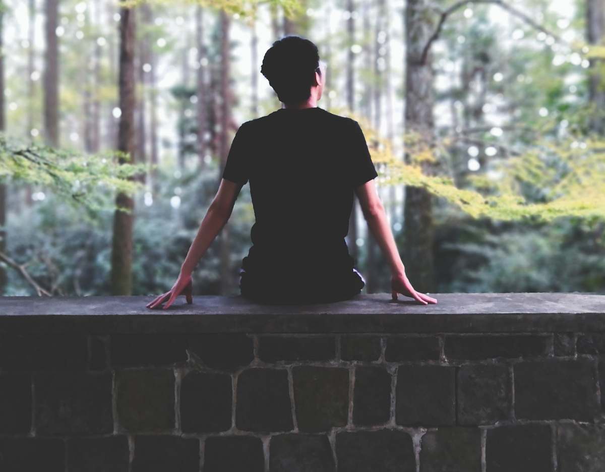 people man sitting on brown concrete bench during daytime person