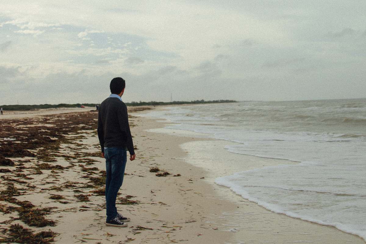 people man standing at beach during daytime person