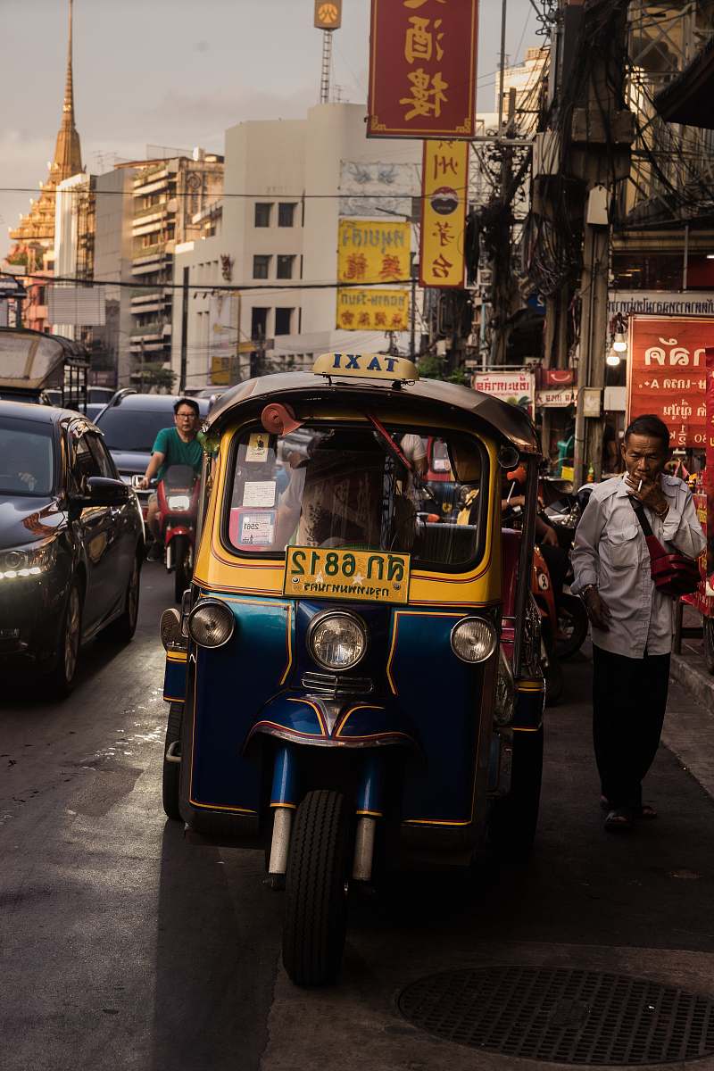 people man standing beside yellow auto rickshaw thailand