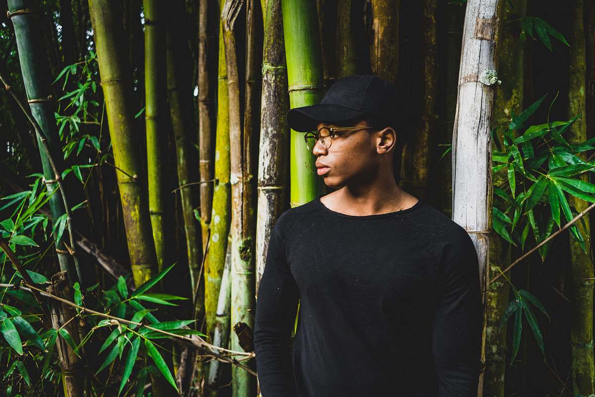 bamboo man standing front of bamboo tree while looking sideward plant