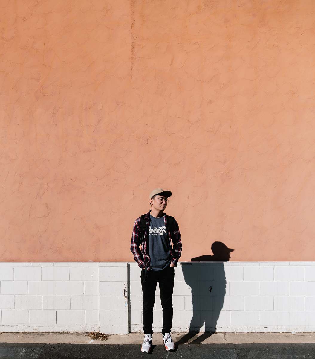 person man standing in front of brown wall people