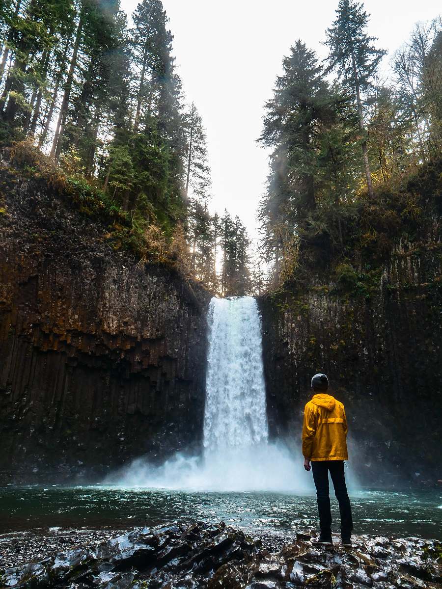 person man standing in front of water falls people