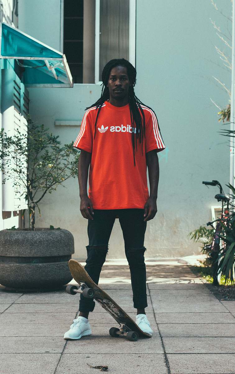 people man standing near gray garden pot with skateboard skateboard