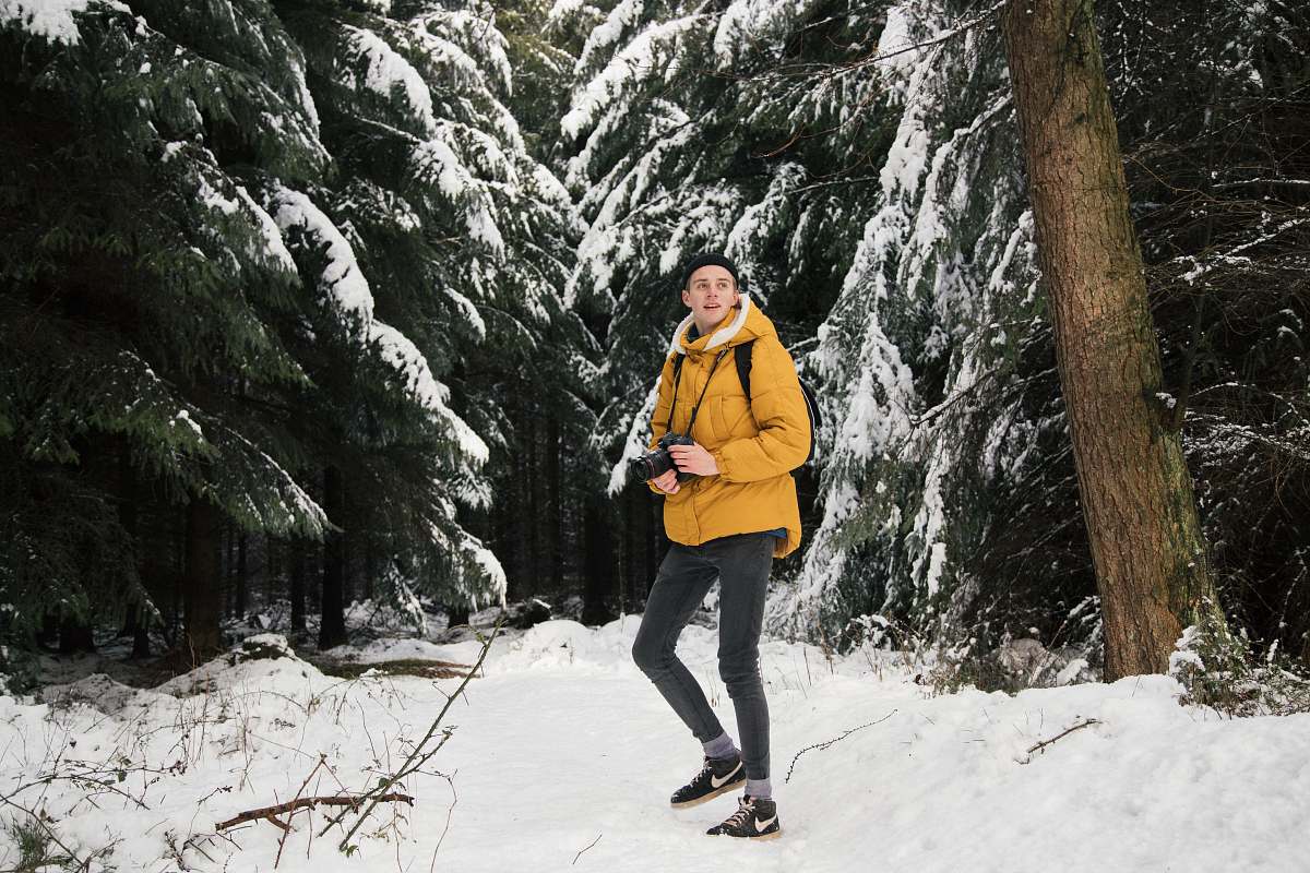 person man standing near trees holding camera people
