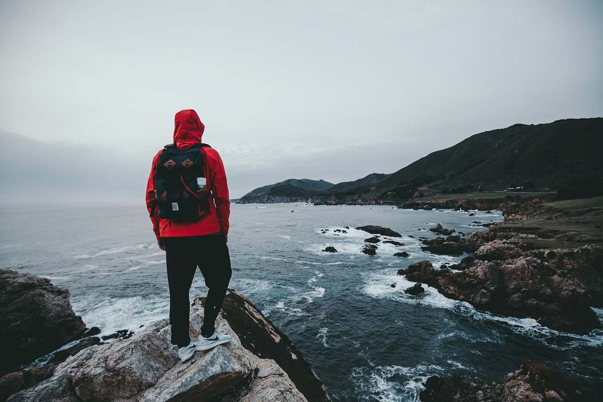 people man standing on gray and black rock formation person