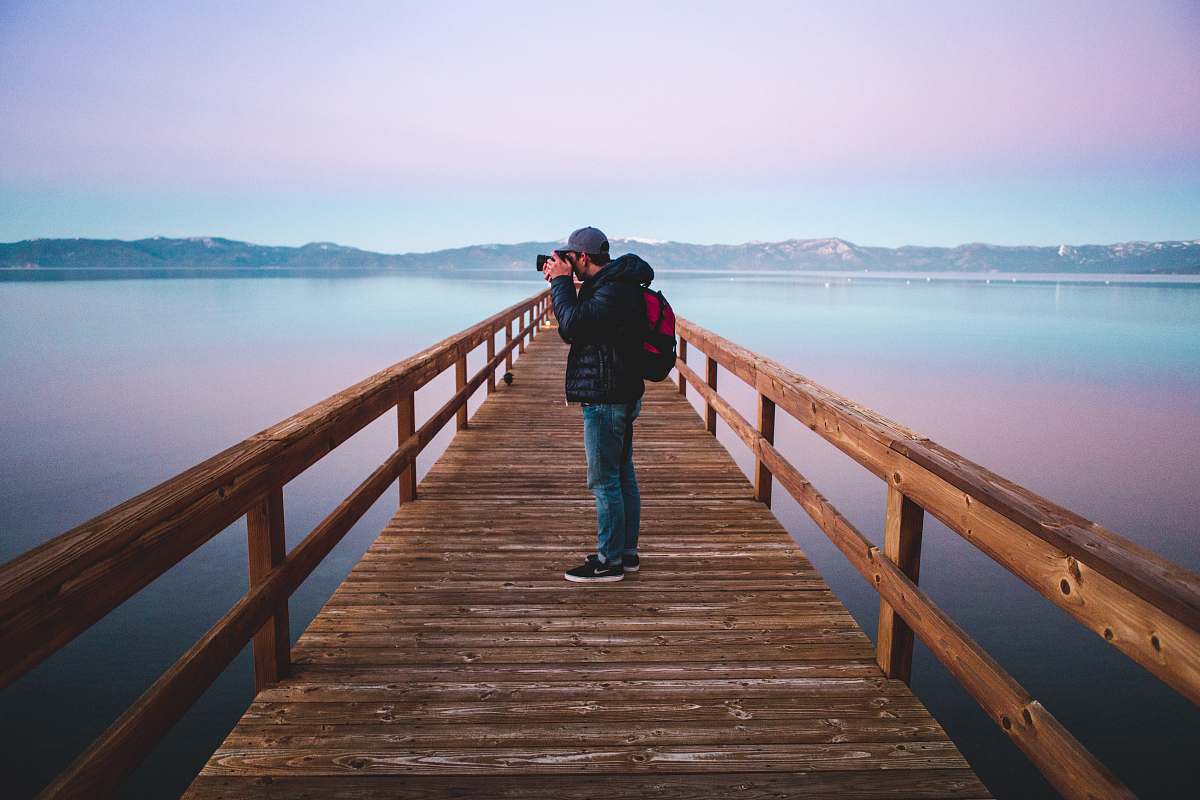 people man standing on wood dock taking photo person