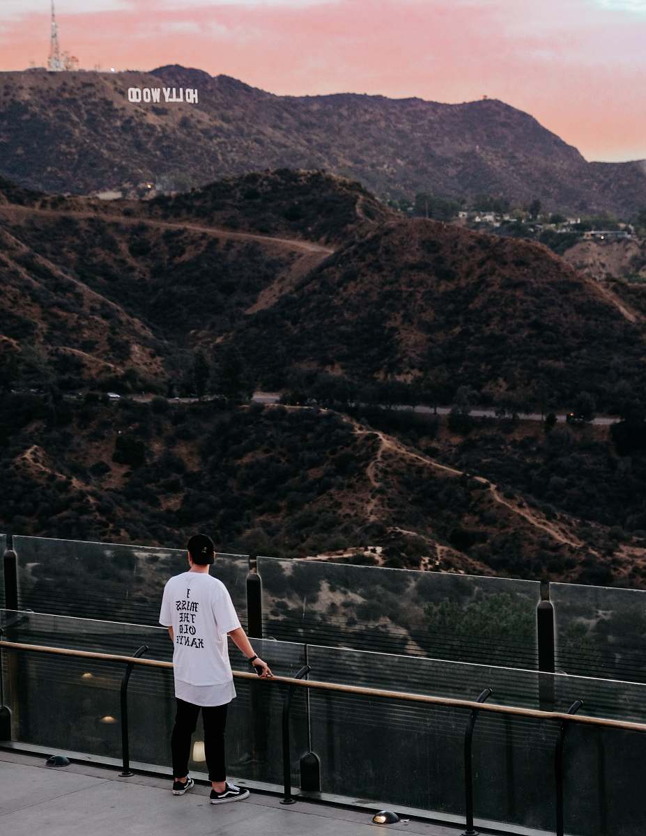 people man standing watching mountain during daytime person