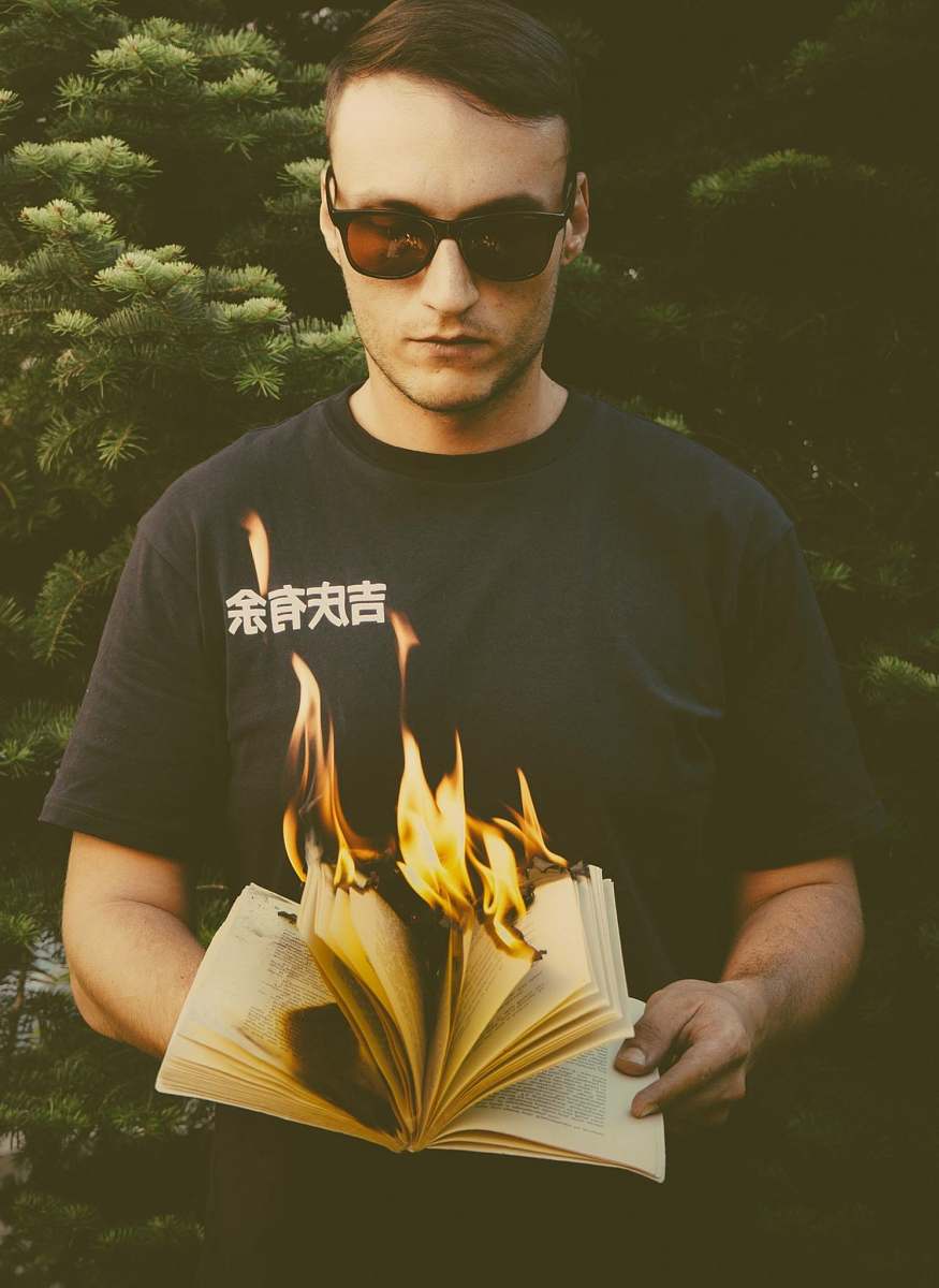 people man standing while holding burning book person